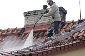 Čištění střechy proudem horké vody při šetrném tlaku na střeše z pálených tašek.