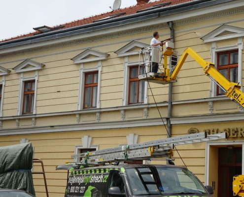 Mytí fasády staršího domu z výškové plošiny.